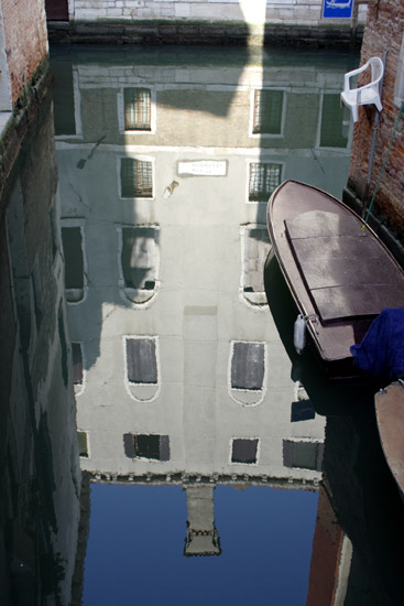 Canal reflection of a house in Venice.