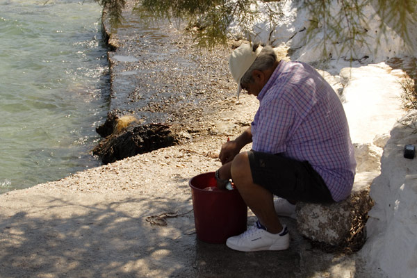 Mand renser fisk p&aring; Leros