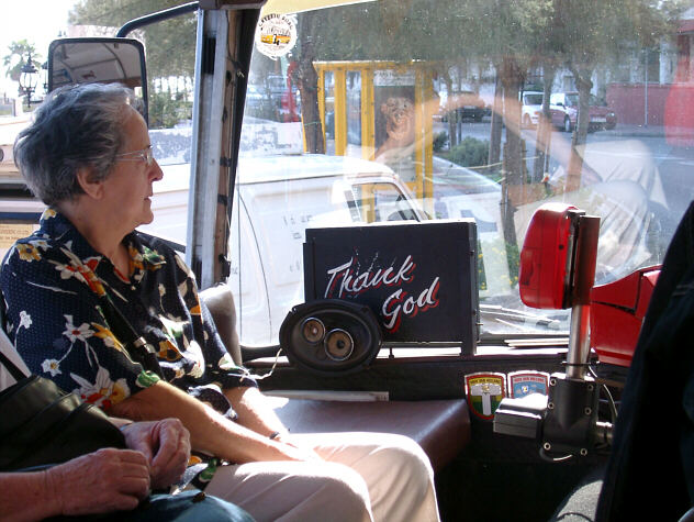 Ved siden af buschauff&oslash;ren er et skilt med 'Thank God'