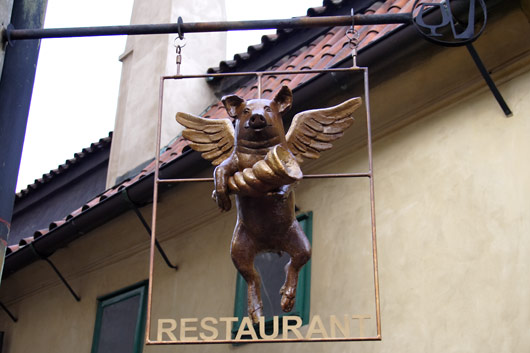 Restaurant sign with winged pig in Golden Lane