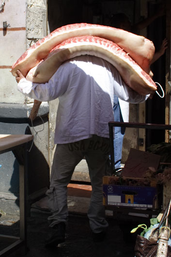 Mand med to halve grise p&aring; Catanias marked